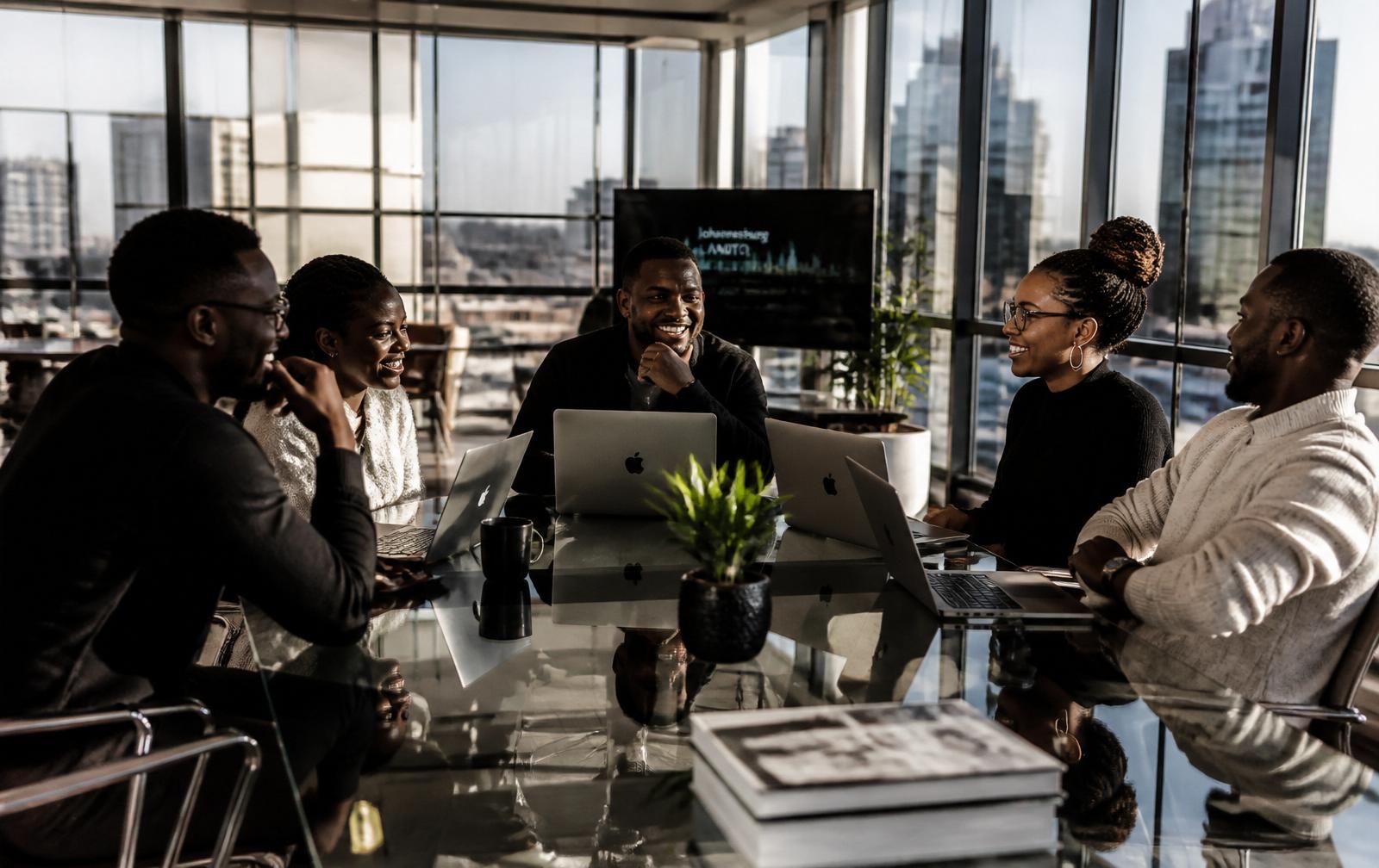 Equipa africana da MzansiBot em Sandton, Joanesburgo, a colaborar em torno de uma mesa moderna